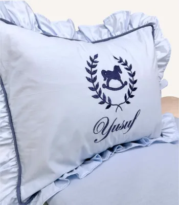 Bebek mavisi ve indigo mavi fırfırlı pamuklu bebek nevresim takımı, nakış detaylı dekoratif yastıklı set