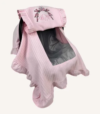 Pembe örgü pike kumaştan fırfırlı, kapaklı puset örtüsü; tül pencereli ve kişiselleştirilebilir nakış detaylı model.