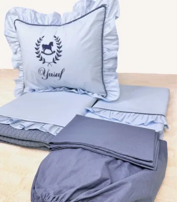 Bebek mavisi ve indigo mavi fırfırlı pamuklu bebek nevresim takımı, nakış detaylı dekoratif yastıklı set