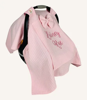 Pembe örgü pike kumaştan, sade kapaklı, tül pencereli ve fiyonklu puset örtüsü.